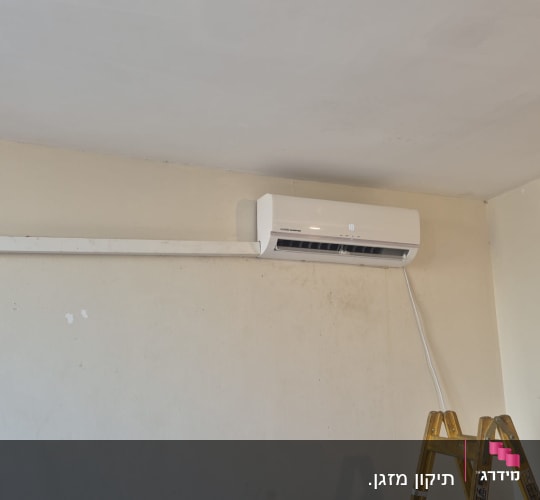מזגן מותקן על קיר עם סולם לידו